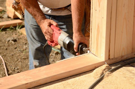 Man using a reciprocating saw to cut out the door